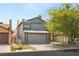 Gray two-story home with a well-maintained lawn and mature tree providing shade at 4197 Tolkien Ave, Las Vegas, NV 89115