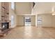 Spacious living room with a brick fireplace, tile flooring, and access to the kitchen at 4197 Tolkien Ave, Las Vegas, NV 89115
