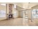 Cozy living room with a brick fireplace, sliding glass doors, and an adjoining kitchen at 4197 Tolkien Ave, Las Vegas, NV 89115