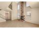 Comfortable living room with a brick fireplace, staircase, and large windows for ample natural light at 4197 Tolkien Ave, Las Vegas, NV 89115