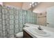 Bathroom features patterned shower curtain, white tile countertops, and a single sink at 4212 Herblinda Ln, North Las Vegas, NV 89032