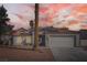 Charming single-story home featuring a well-manicured front yard and a two-car garage under a colorful sunset sky at 4212 Herblinda Ln, North Las Vegas, NV 89032