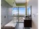 Modern bathroom features a large soaking tub with mosaic tile wall and stunning city views through expansive windows at 4471 Dean Martin Dr # 4308, Las Vegas, NV 89103