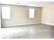 Bright living area with modern tile floors, light walls, and natural light streaming through two windows at 5060 Serene Skies St, Las Vegas, NV 89130