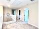 Upstairs hallway with carpet, modern lighting, and access to multiple rooms, with white railing at 5060 Serene Skies St, Las Vegas, NV 89130
