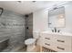 Renovated bathroom featuring a modern vanity and a tiled walk-in shower with a built-in bench at 5069 Hallet Dr, Las Vegas, NV 89122