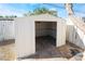 Exterior view of the backyard storage shed with exposed interior, a sliding door, and concrete foundation at 5069 Hallet Dr, Las Vegas, NV 89122