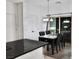 Bright dining area with a modern chandelier, black table and chairs, and sliding glass doors at 649 Ryan Peak Ln, Henderson, NV 89011