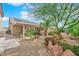 Landscaped backyard featuring desert landscaping, covered patio, seating area, and solar panels above at 6781 Alpine Brooks Ave, Las Vegas, NV 89130