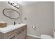 Elegant powder room with a modern vanity, stylish mirror, and brushed bronze fixtures at 6781 Alpine Brooks Ave, Las Vegas, NV 89130