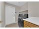 Bright laundry room featuring a modern washer and dryer, storage, and backyard access at 6781 Alpine Brooks Ave, Las Vegas, NV 89130