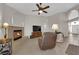 Open living room features a fireplace, ceiling fan, and view to front entrance at 6781 Alpine Brooks Ave, Las Vegas, NV 89130