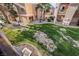 Green backyard area with lush landscaping and views of the community buildings at 6857 Tamarus St # 202, Las Vegas, NV 89119