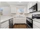 A well-lit kitchen features white cabinetry and stainless steel appliances at 6857 Tamarus St # 202, Las Vegas, NV 89119
