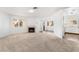 Bright living room featuring a fireplace, carpet flooring, and multiple windows at 6857 Tamarus St # 202, Las Vegas, NV 89119