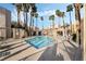 Community pool surrounded by palm trees and lounge chairs at 6857 Tamarus St # 202, Las Vegas, NV 89119