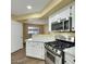 Modern kitchen featuring stainless steel oven range, white countertops, and ample cabinet space at 698 S Racetrack Rd # 412, Henderson, NV 89015