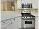Modern kitchen with stainless steel oven range, white countertops, and ample cabinet space at 698 S Racetrack Rd # 412, Henderson, NV 89015