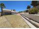 Spacious backyard featuring desert landscaping, a retaining wall, and a view of the home's exterior at 7417 Red Eagle St, Las Vegas, NV 89131