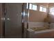 Bathroom view of jacuzzi tub with shower and white tile surround under horizontally-aligned windows at 7417 Red Eagle St, Las Vegas, NV 89131