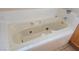 Close-up of a white jacuzzi tub with white tile surround, featuring gold fixtures at 7417 Red Eagle St, Las Vegas, NV 89131