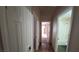 Neutral hallway showcasing doors and bathroom with shower over the tub and earth-toned tile flooring at 7417 Red Eagle St, Las Vegas, NV 89131