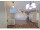 Spacious living room area with tile flooring, plush carpet, and a vaulted ceiling with a ceiling fan at 7417 Red Eagle St, Las Vegas, NV 89131