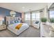This bedroom features a large bed, natural light, and calming blue accent wall for a relaxing ambiance at 7915 Pandora Sky St # 402, Las Vegas, NV 89084