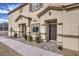 Exterior of a two-story townhome featuring a brown front door, beige stucco, and landscaped walkway at 7915 Pandora Sky St # 402, Las Vegas, NV 89084