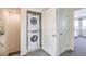 Upstairs laundry closet featuring a stacked washer and dryer with carpeted floors at 7915 Pandora Sky St # 402, Las Vegas, NV 89084