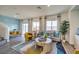 Bright living room with gray sofa, colorful rug, modern furniture, and large windows with stylish curtains at 7915 Pandora Sky St # 402, Las Vegas, NV 89084