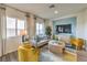 Bright living room with gray sofa, colorful rug, modern furniture, and large windows with stylish curtains at 7915 Pandora Sky St # 402, Las Vegas, NV 89084