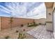 Low-maintenance backyard with gravel, a small patch of green turf, and paved patio area at 7915 Pandora Sky St # 403, North Las Vegas, NV 89084
