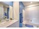 Bright bathroom featuring a tub, vanity, and white-tiled shower, creating a functional and stylish space at 7915 Pandora Sky St # 403, North Las Vegas, NV 89084