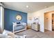 Bedroom with white crib and nautical decor, featuring a blue accent wall and natural light at 7915 Pandora Sky St # 403, North Las Vegas, NV 89084