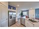 Modern kitchen adjacent to a dining area with stainless steel appliances, white cabinets, and granite countertops at 7915 Pandora Sky St # 403, North Las Vegas, NV 89084
