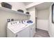 Convenient laundry room with modern washer and dryer, plus overhead shelving at 7915 Pandora Sky St # 403, North Las Vegas, NV 89084