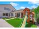 Inviting backyard with a slide, playhouse, seating area, and well-maintained artificial grass at 8000 Clock Tower Ct Ct, Las Vegas, NV 89117