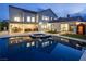 An elegant outdoor living space with a pool, spa, patio, and lush greenery under the evening sky at 8000 Clock Tower Ct Ct, Las Vegas, NV 89117