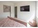 Bedroom features a soft pink bed, TV, neutral artwork, and sunny window at 8000 Clock Tower Ct Ct, Las Vegas, NV 89117