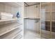 Well-organized walk-in closet featuring adjustable shelves, hanging rods, and glass-door cabinets for optimal storage at 8000 Clock Tower Ct Ct, Las Vegas, NV 89117