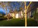 Inviting two-story home with manicured lawn, trees, and charming exterior lighting at 8000 Clock Tower Ct Ct, Las Vegas, NV 89117