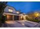A well-lit home featuring a three-car garage with stone accents and a wide driveway at 8000 Clock Tower Ct Ct, Las Vegas, NV 89117