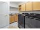 Efficient laundry room featuring full-size washer and dryer, ample storage cabinets, and utility sink at 8000 Clock Tower Ct Ct, Las Vegas, NV 89117