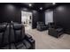 An open view of a home theater with luxurious reclining seats and a screen, flowing into a living space at 8000 Clock Tower Ct Ct, Las Vegas, NV 89117