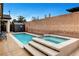 This backyard features a pool and attached hot tub, plus an outdoor storage shed and brick wall at 8811 Pauley Hills St, Las Vegas, NV 89131