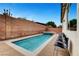 This backyard features a long pool with an attached hot tub and black chairs at 8811 Pauley Hills St, Las Vegas, NV 89131