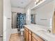 Bright bathroom featuring a bathtub with shower, wooden cabinets and a large mirror at 8811 Pauley Hills St, Las Vegas, NV 89131