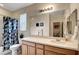 Bright bathroom featuring a bathtub with shower, wooden cabinets and a large mirror at 8811 Pauley Hills St, Las Vegas, NV 89131