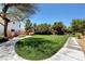 Well-maintained common area with lush green grass, trees, and a walking path at 8811 Pauley Hills St, Las Vegas, NV 89131